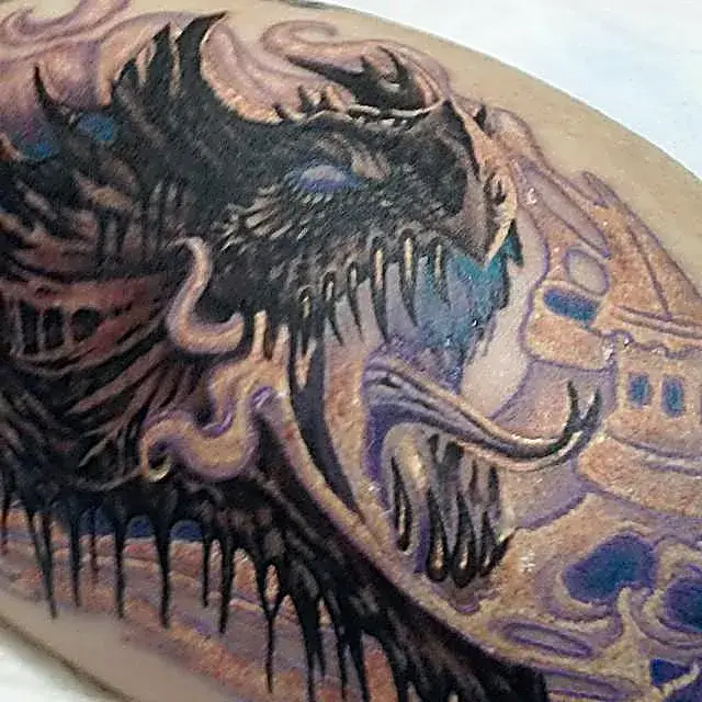 Another angle, same beast: Dragon tattoo with fierce detail and swirling fantasy backdrop.