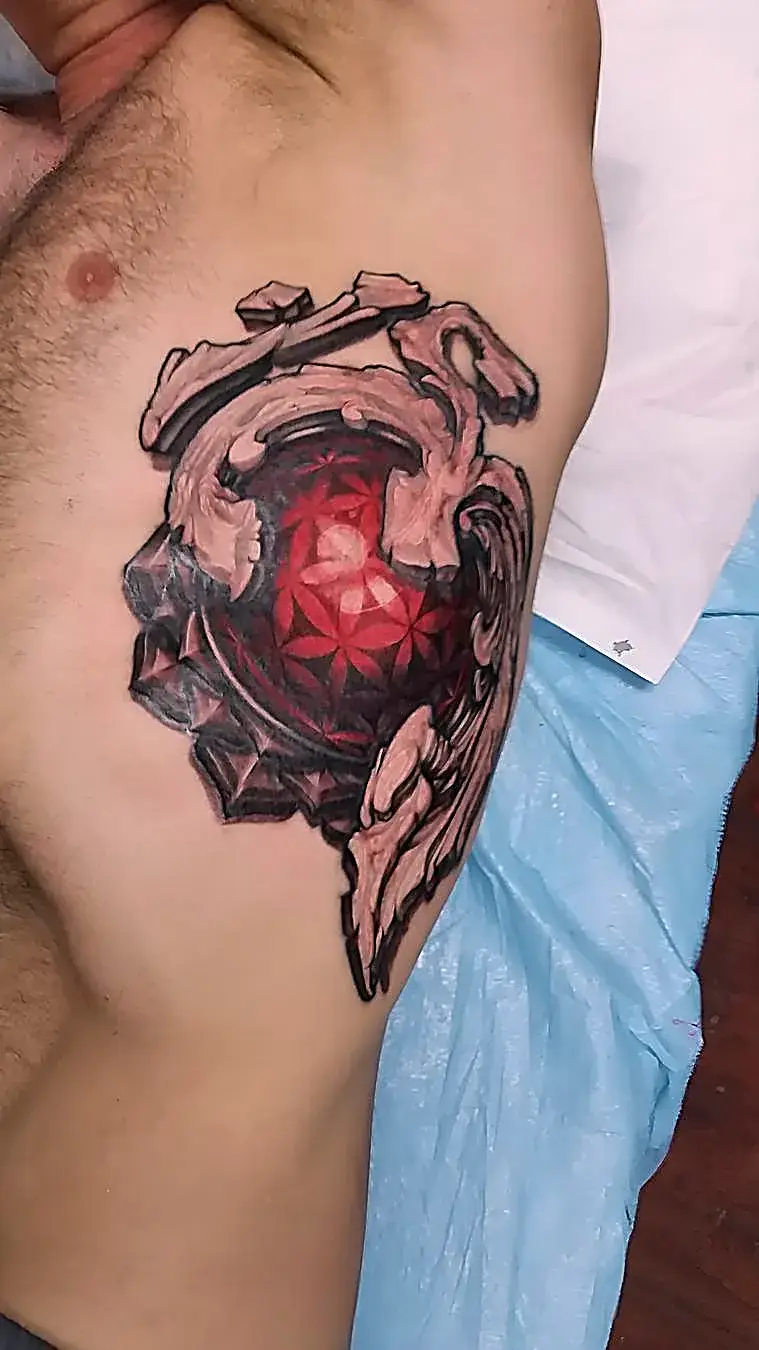 Sacred geometry meets body art: Ohm and Flower of Life tattoo on the left ribs.