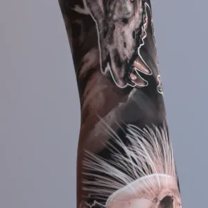 Scorched and Thriving Earth arm sleeve tattoo with porcupine skull, wolf face, and animal skulls in black and gray realism